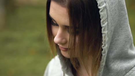 Extreme-Close-Up-Shot-Of-Pretty-Girls-Face-In-Hoodie-Smiling-And-Looking-Down