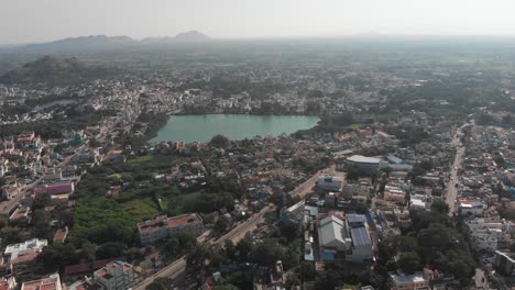 Aerial-view-of-natural-pond-in-Tiruvannamalai-surrounded-by-city-during-sunny-day-in-India