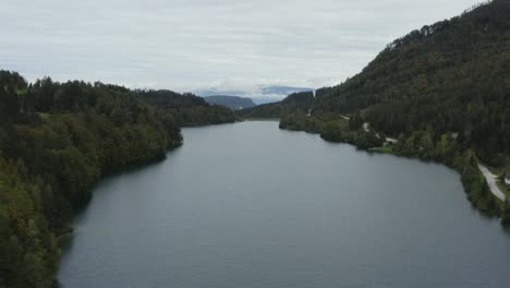 Freibach-reservoir-at-southern-Austrian-Alps-country-on-overcast-day,-Aerial-flyover-rising-shot