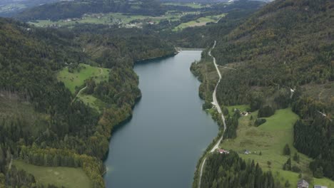 Full-view-of-Freibach-reservoir-in-Austria-looking-at-north-shore,-Aerial-tilt-up-reveal-shot