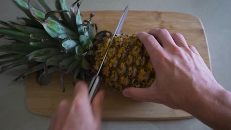 Mann-Legt-Ananas-Auf-Schneidebrett-Und-Beginnt,-Die-Köstliche-Frucht-Zuzubereiten