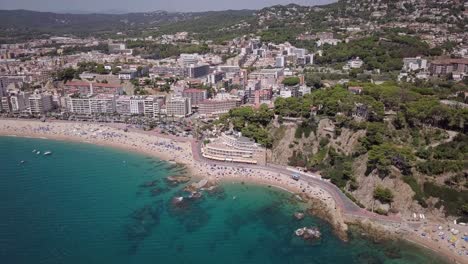 Overview-of-Lloret-de-Mar-in-the-sun-with-a-drone-view-on-the-beach-and-village