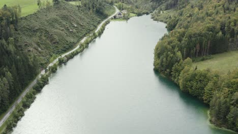 Water-and-mountain-view-of-Freibach-reservoir-in-Austria-towards-the-south-shore,-Aerial-tilt-up-reveal-shot