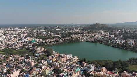 Beautiful-green-lake-surrounded-by-large-indian-city-during-sunny-day