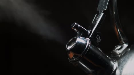 Steam-from-kettle-spout-on-black-background,-dramatic-close-up
