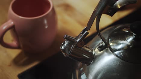 Tea-cup-and-steam-kettle-on-kitchen-table,-close-up,-tea-is-ready