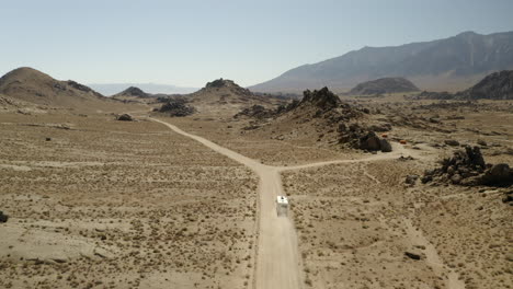 Drone-following-RV-driving-in-the-desert-with-mountains-in-Alabama-Hills-on-American-road-trip
