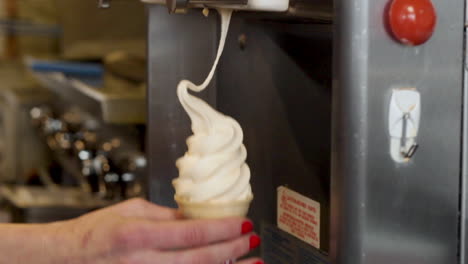 Female-hand-Filling-Rotating-Cone-With-Soft-Serve-Ice-Cream-From-Machine