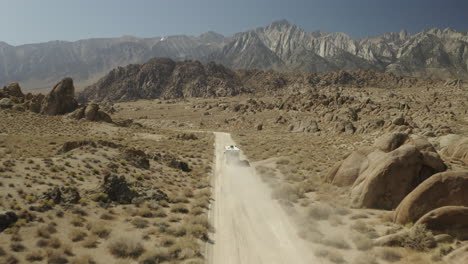 Drone-footage-of-Iconic-off-road-track,-with-RV-driving-towards-Sierra-Nevada-mountains-in-Alabama-Hills-on-American-road-trip