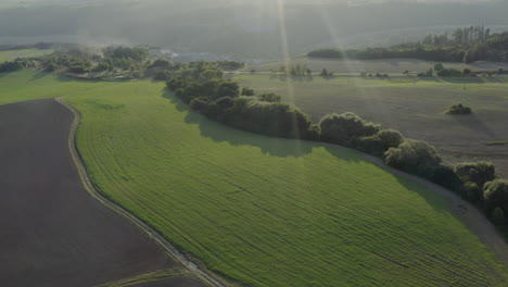 Aerial-Shot-Of-Farm-Land-And-Mountains-At-Sunrise,-Natural-Rural-Czech-Republic-Landscape