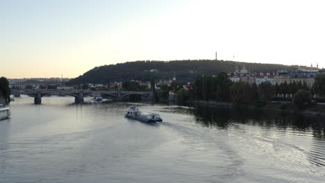 Cruise-ship-on-Vltava-river-in-the-evening,Prague-city-skyline,Czechia