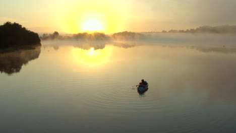 Drone-footage-of-misty-sunrise-morning-of-people-kayaking-on-a-lake-in-the-English-countryside