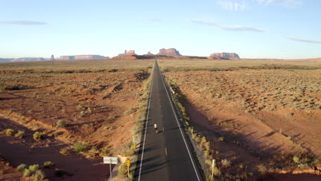 Smooth-Drone-footage-of-man-skateboarding-in-Monument-valley-along-forest-Gump-highway-in-Utah