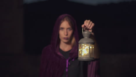 Mysterious-woman-holding-a-lantern-walks-in-slow-motion-towards-the-camera-and-gets-in-focus