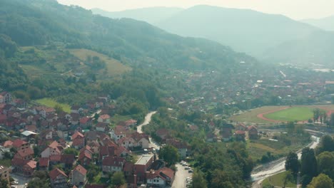 Aerial-flyover-of-the-valley-town-of-Ivanjica,-Serbia-on-a-bright-day