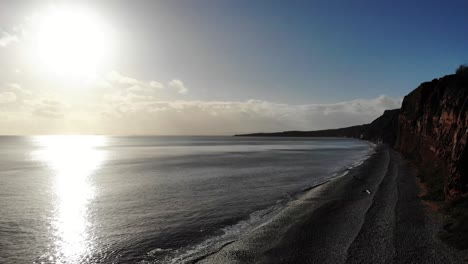 Vista-Aérea-Mirando-Hacia-El-Sol-Desde-Budleigh-Salterton-Beach-Devon,-Inglaterra