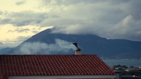 Smoke-coming-out-of-a-chimney-rotating-cap-of-a-tiled-roof-on-a-cold-winter-day