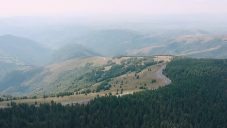 Road-by-the-edge-of-the-green-forest-in-Golija,-Serbia--aerial