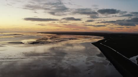 Aerial-Golden-Orange-Sunset-Reflections-Above-Waters-In-Ameland