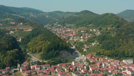 Aerial-flyover-shot-of-the-valley-town-of-Ivanjica-in-Serbia-on-a-bright-day
