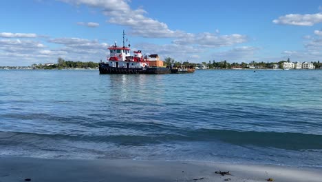 Sarasota,-Florida---December-19,-2020:-A-dredger-sitting-in-the-clear-blue-water-of-an-inlet-from-the-Gulf-of-Mexico