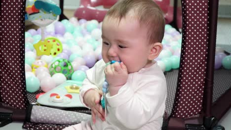 Lovely-Baby-Girl-On-Her-Playing-Area-At-Home-With-Colorful-Play-Balls-In-Background