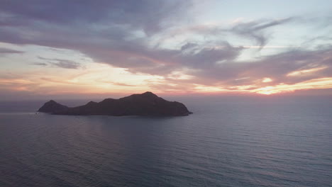 Hermosa-Vista-De-La-Pequeña-Isla-En-El-Océano-Al-Atardecer