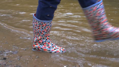 Young-child-walking-and-splashing-water-in-welly-boots-2
