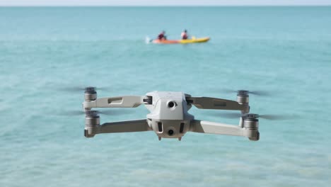Drone-Flotando-Con-El-Océano-Y-Un-Par-De-Kayak-En-El-Fondo