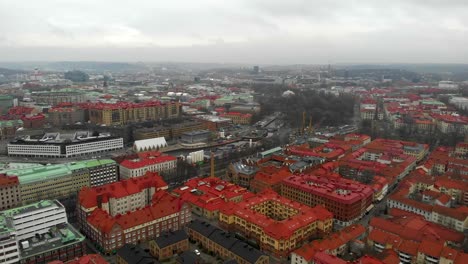 Stunning-zoom-out-aerial-view-of-downtown-Haga-city-center-with-skyline-and-buildings-on-a-cloudy-and-rainy-winter-day-in-Gothenburg-City,-Sweden