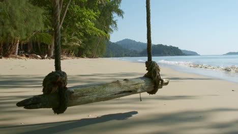Tropischer-Weißer-Sandstrand-Mit-Seilschaukel,-Kleinen-Wellen-Und-Tropischen-Bäumen