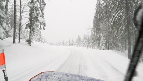 View-out-of-drivers-cab-of-snow-plow-while-clear-snowy-road