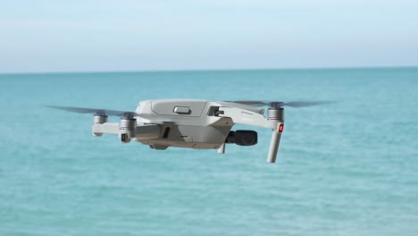 side-view-of-drone-hovering-with-ocean-and-blue-sky-in-background