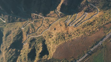 Top-down-aerial-view-of-sierra-tropical-rainforest-road,-Serra-Do-Rio-Do-Rastro-and-the-mountains-of-Santa-Catarina-at-sunrise