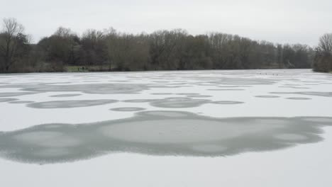 Drone-aerial-footage-of-a-4k-drone-flying-very-close-over-a-frozen-lake-in-Germany