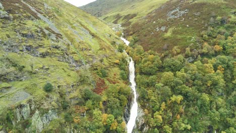 Idyllic-Snowdonia-mountain-range-Aber-falls-waterfalls-national-park-aerial-pull-away-fast-view