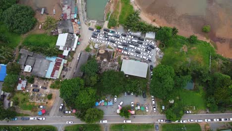 AERIAL:-Top-down-Shot-of-a-Parking-Zone-at-coastline-full-by-Cars-what-stuck-in-the-Queue-waiting-for-the-Ferry-from-Koh-Chang-Island-to-Mainland,-Trat,-Thailand,-Asia