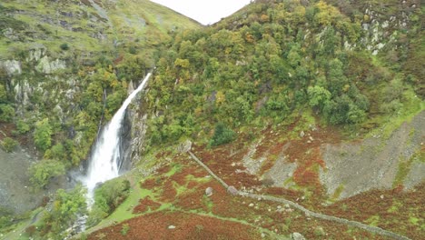 Idyllic-Snowdonia-mountain-range-Aber-falls-waterfalls-national-park-aerial-view-dolly-right