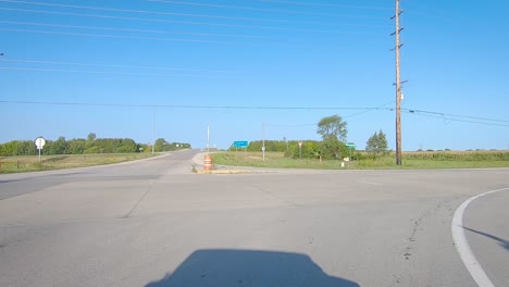 POV-driving-on-a-rural-paved-road,-turning-a-corner-at-a-stop-sign