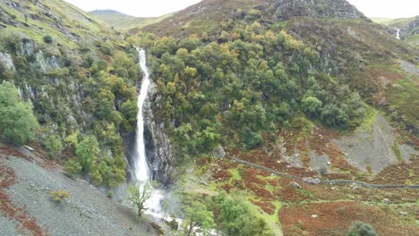 Idyllic-Snowdonia-mountain-range-Aber-falls-waterfalls-national-park-aerial-descending-tilt-upwards-view