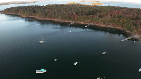 Aerial-High-Pan-Footage-at-Cousins-Island-Maine-boat-harbour-overlooking-parked-boats,-revealing-horizon