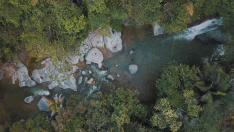 Vista-En-Perspectiva-Aérea-De-Drones-De-Personas-Nadando-En-Un-Río-En-Medio-De-Un-Bosque-En-Colombia