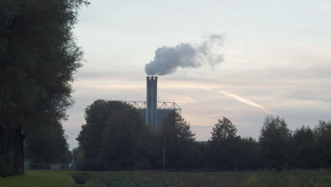 Polluting-smoking-factory-chimney-against-a-sunset-in-realtime