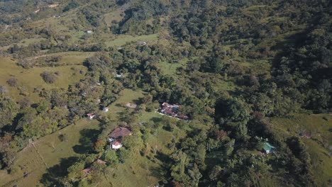 Drone-aerial-view,-beautiful-valley-landscape-with-hills-and-a-forest-in-Colombia