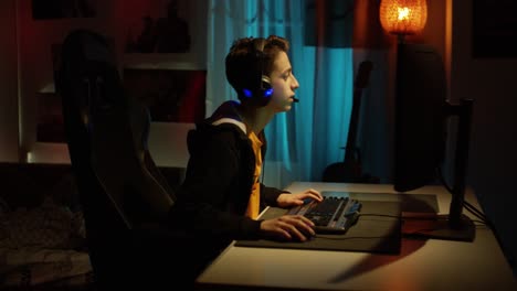 Teenager Boy Online Plays A Computer Game With Headphones And A