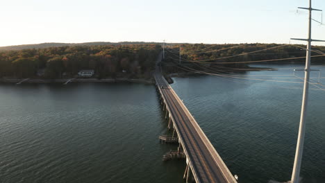 Aerial-Flyover-footage-at-causeway-with-powerlines-leading-into-mainland-at-Yarmouth,-USA