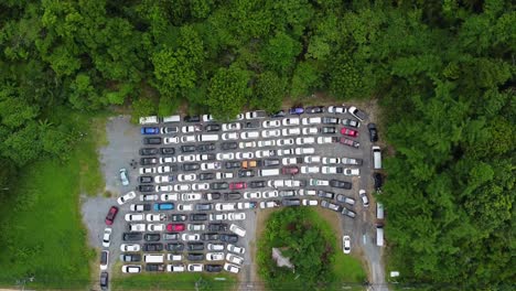 AERIAL:-Drone-flying-above-a-Highway-Pocket-full-by-Cars-surrounded-by-Jungle-forest,-People-stuck-in-the-Queue-waiting-for-Ferry-from-The-Koh-Chang-Island-to-Mainland,-Thailand,-Asia