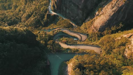 Car-driving-by-on-the-most-beautiful-and-dangerous-rainforest-brazilian-roads-at-sunrise-aerial-top-down-view,-Serra-do-Corvo-Branco,-Grão-Pará,-Brazil
