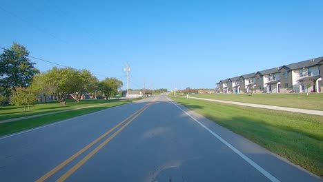 POV-driving-on-a-paved-road-thru-the-edge-of-a-small-town-in-Hills,-Iowa