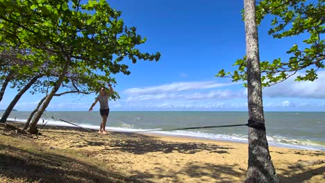 Young-Adult-Male-Getting-On-Slackline-And-Walking-At-Trinity-Beach-In-Cairns
